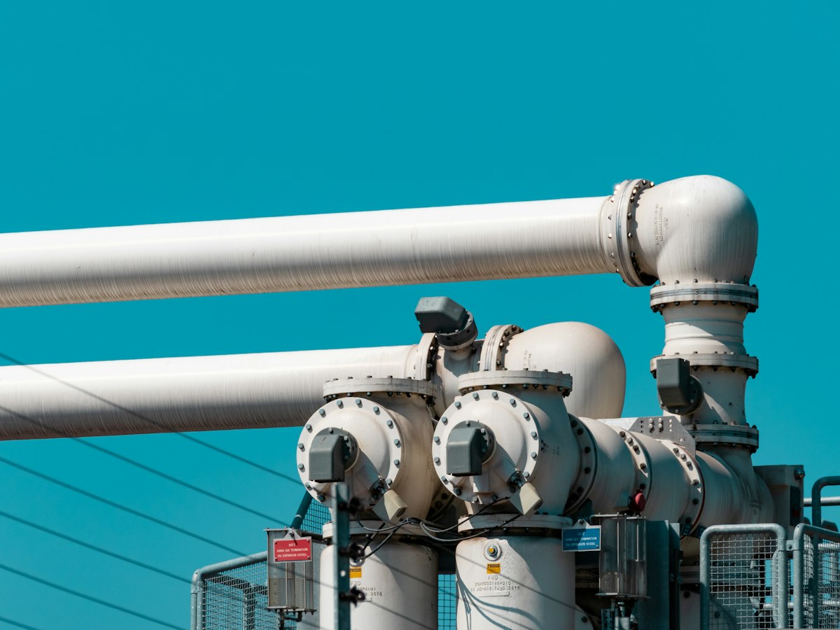 Industrial pipework and valves against a blue sky