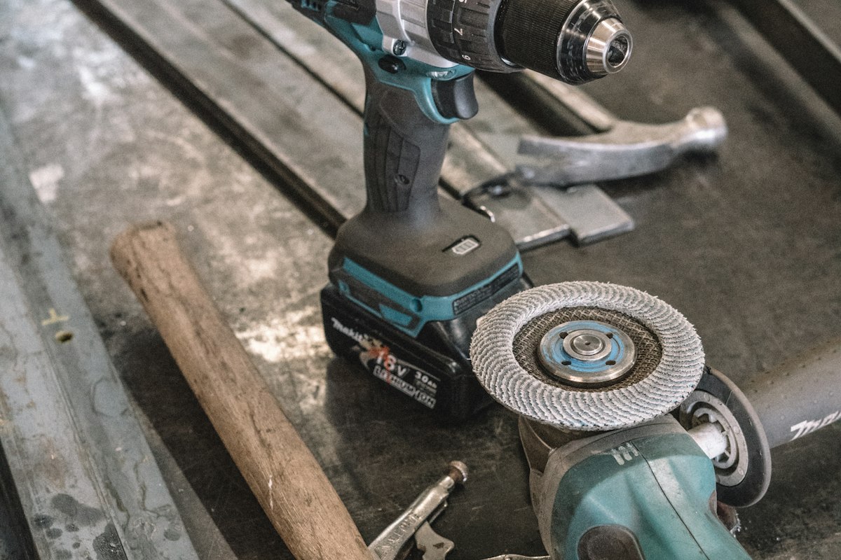 Cordless drill and angle grinder on a workbench