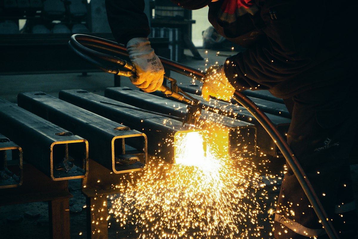 Welder working on steel in a workshop